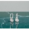 Small silver hoop earrings with dangling hearts