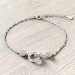 Elegáns ezüst karkötő egymásba fonódó karika medállal